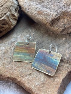 Brass earrings are one square inch dangles with a patina finish mimicking a desert sunset. No two pairs are alike and feature tones of rust, blue, tan with a hint of brass. the ear wires are handmade sterling silver. Brown Rectangular Earrings With Ear Wire, Nickel-free Multicolor Rectangular Earrings, Rectangular Copper Earrings With Ear Wire, Rectangular Patina Jewelry As Gift, Artisan Nickel-free Rectangular Earrings, Nickel-free Rectangular Copper Jewelry, Desert Sunset, Patina Finish, Brass Earrings