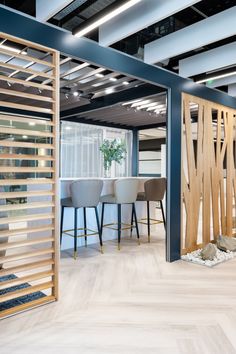 an office with wooden slats and chairs in the center, next to a plant