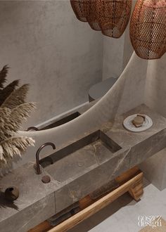 a bathroom sink sitting next to a toilet in a room with two lights hanging above it