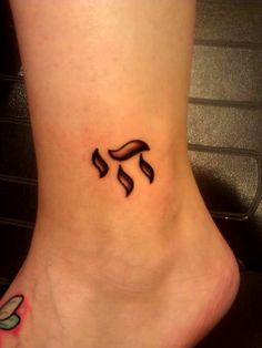 a woman's foot with a small tattoo on the side of her leg and an arrow in the middle