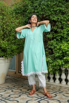 Dusty jade kurtapant set is perfect for a festive season or a day out .Cotton cambric fabric makes it perfect for summer weather. Front v-neckline kurta with lace detail bell sleeves give a classic look. Product has no lining. Pant has two side pockets, back elasted waistband and lace on the hem. Cold wash and Dry clean only.Type of Work: Solid Fit: Loose Model Height: 5'7 Measurements: Kurta-36.5" Pant- 34" SKU#: 11702071GR Disclaimer: There may be slight difference in actual product color comp Festive Spring V-neck Kurta, V-neck Kurta With Chikankari Embroidery For Spring, Spring V-neck Kurta With Chikankari Embroidery, Spring Chikankari Embroidery V-neck Set, Spring V-neck Chikankari Embroidered Sets, Festive V-neck Kurta For Vacation, Summer Festive V-neck Kurta, Festive Straight Kurta With Lace Trim, Green Lace Work Sets For Spring