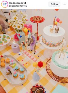 a table topped with lots of cakes and cupcakes