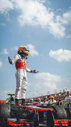 a man standing on top of a race car