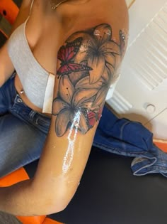 a woman with a butterfly tattoo on her arm sitting down and looking at the camera