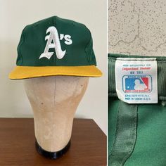 a green and yellow baseball cap sitting on top of a mannequin's head