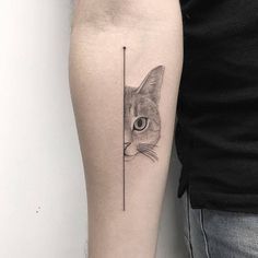 a cat behind a pole tattoo on the arm