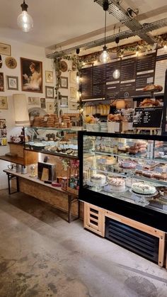 the inside of a bakery with lots of food on display in it's glass cases