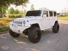 a white jeep is parked on the street