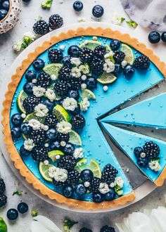 a pie with blueberries, limes and blackberries on it