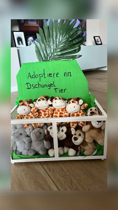 there are many stuffed animals in the box with green paper on top that says adoptter're en distumet tier