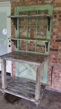 an old wooden table sitting in front of a brick wall with shelves on each side