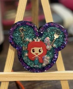 the little mermaid heart shaped brooch is on display