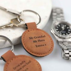 two leather keychains with the words my grandad, my hero and a watch