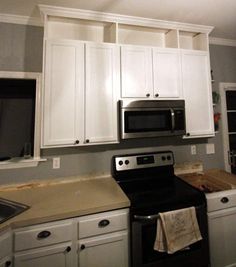 a kitchen with white cabinets and black appliances