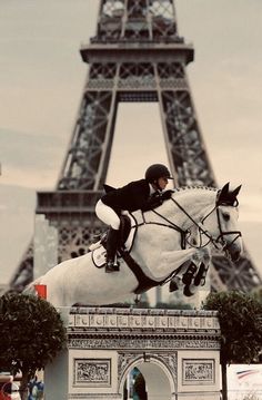 a person riding a horse in front of the eiffel tower