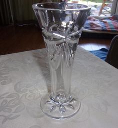 a clear glass vase sitting on top of a white tablecloth covered dining room table