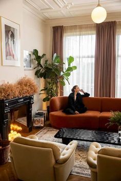 a woman sitting on top of a couch in a living room