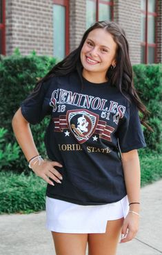 Get ready to rock your game day look with The FSU Pep Rally Thrifted Tee! This unique shirt features a vintage, lived-in feel and a bit of distressing for a cool, preppy vibe. Size up for the perfect oversized look and get ready to rally in style. Details: *OFFICALLY LICENSED* Distressed, Thrifted Knit Tee 100% Preshrunken Cotton Crew Neckline, Short Sleeve, Slightly Oversized Features Oversized Seminole graphic, center chest Color: Vintage Black True to Size: Relaxed Fit, Size up for more oversized Fit Julia is wearing size Small Garment measurements in inches: Small = Bust: 19” / Length: 26” Medium = Bust: 21” / Length: 27” Large = Bust: 23” / Length: 28” X-Large = Bust: 25” / Length: 29” Have questions about sizing, fit, or styling? Send us a chat or give us a call at 850-629-4890 durin Tallahassee Florida, Pep Rally, Fashion Bottoms, Florida State University, Florida State Seminoles, Unique Shirt, Color Vintage, Alabama Crimson, Florida State