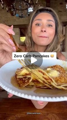 a woman is holding a plate with pancakes on it and the caption reads, zero carb pancakes