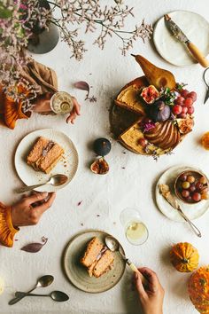 people are sitting at a table with food and drinks on it, including cake slices