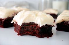 three chocolate cupcakes with white frosting on a plate