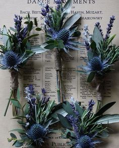 blue flowers and greenery are arranged on an old book