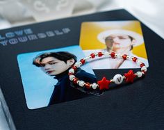 "Show your love for your favorite member with our BTS bias bracelet. Each bracelet is made of 14k gold filled beads and your choice color of seed beads and two star beads. Pictured photo is in the color \"CRIMSON\". **FOR COLOR OPTIONS PLEASE SEE 3rd PHOTO** Note: Each purchase will come with 2 photocards. They will vary from photo and be randomly selected. Please choose your color in \"PERSONALIZATION\" section. Please message me for any questions :)" Star Beads, Star Bracelet, Grab Bags, Picture Photo, Color Choices, Photo Cards, Favorite Jewelry, Jewelry Pieces, Seed Beads