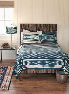 a bed with blue and white bedspread in a bedroom next to a lamp