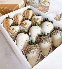 a box filled with chocolate covered strawberries on top of a white table next to other items