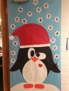 a door decorated with a penguin wearing a santa hat