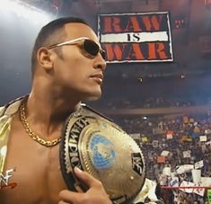 a man holding a wrestling belt in front of a crowd