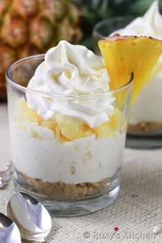 pineapple dessert with whipped cream on top in small glass dishes next to spoons