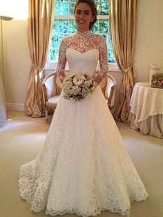 a woman in a wedding dress standing next to a window