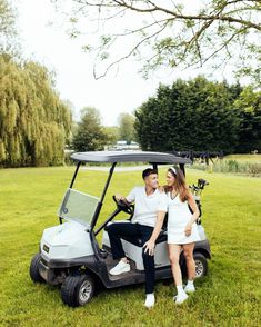 a man and woman sitting in a golf cart