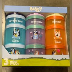 three different colored cups with cartoon characters on them in a cardboard box, one for each child