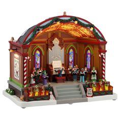 a christmas scene is shown in the shape of a church with lights and decorations on it