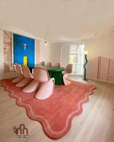 the room is clean and ready to be used as a dining area with pink chairs