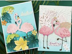 two flamingos are standing next to each other in front of some leaves and flowers