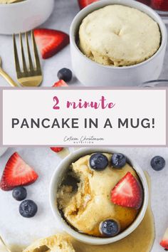 two mugs filled with cake and strawberries on top of a white tablecloth