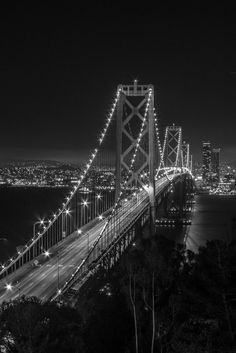 black and white photograph of the bay bridge at night