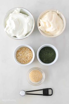 four bowls with different types of creams and seasonings in them on a white surface