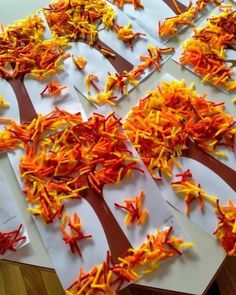 several pieces of paper with orange and yellow flowers cut out of them on top of a table