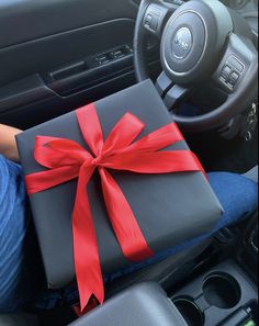 a person holding a wrapped present in their car