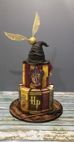 a harry potter themed cake on top of a wooden table with an owl flying over it