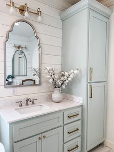 a bathroom with two sinks and a large mirror on the wall above it's cabinets