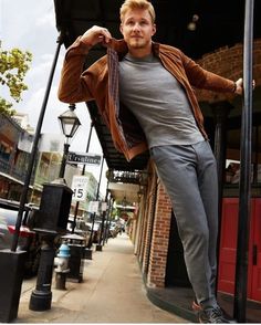 a man leaning on a lamp post in front of a building