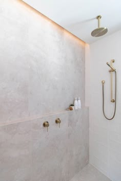 a bathroom with a shower head and hand held shower faucet