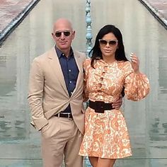 a man and woman standing in front of a fountain