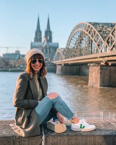 a woman sitting on the edge of a bridge