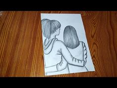 a drawing of two people hugging on top of a wooden table next to a piece of paper